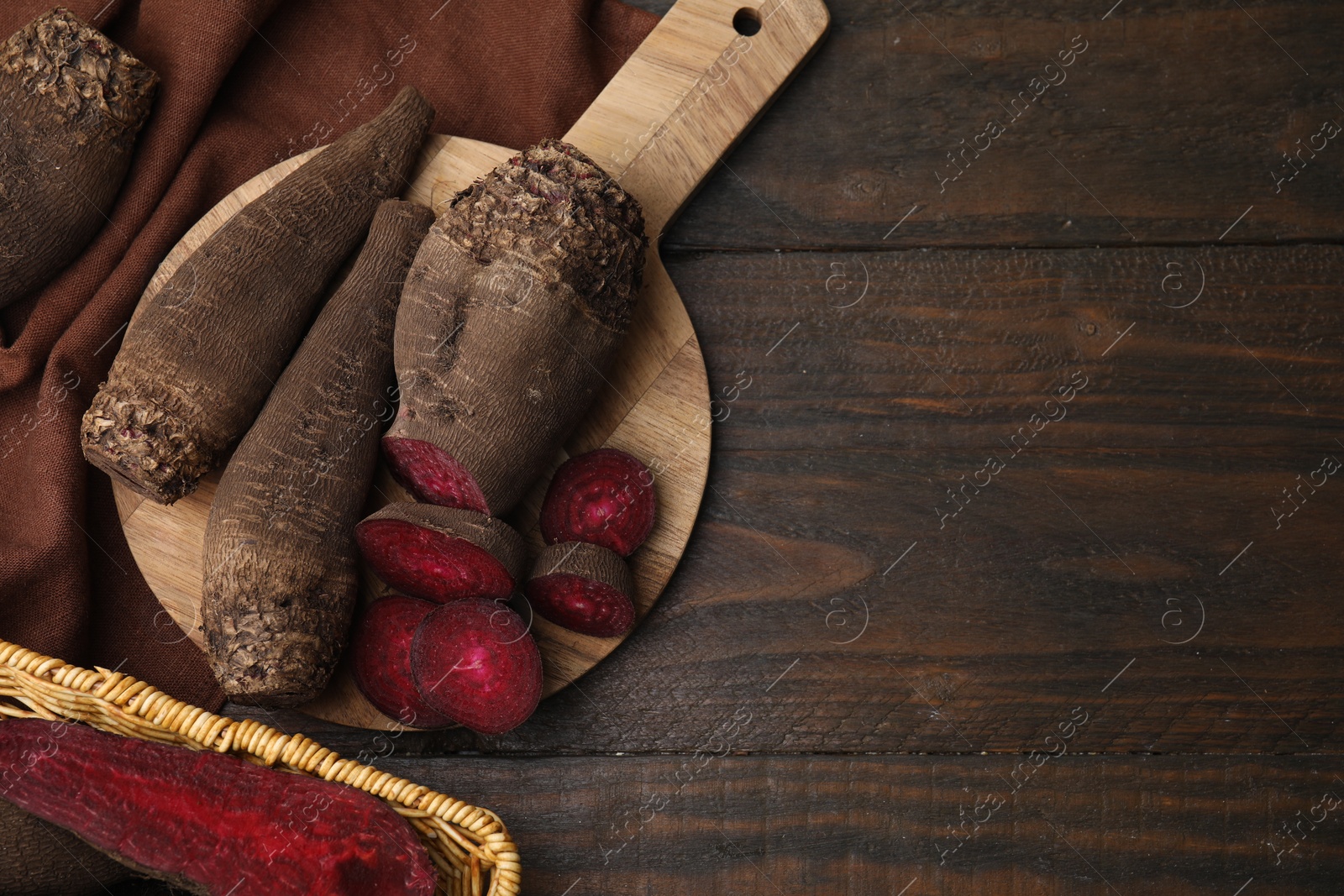 Photo of Whole and cut red beets on wooden table, flat lay. Space for text