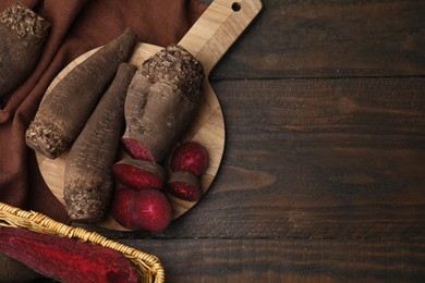 Whole and cut red beets on wooden table, flat lay. Space for text