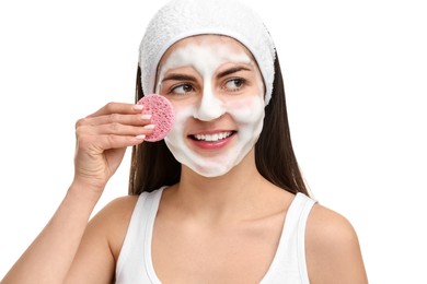 Photo of Young woman with headband washing her face using sponge on white background