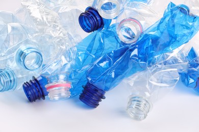 Photo of Crumpled disposable plastic bottles on white background