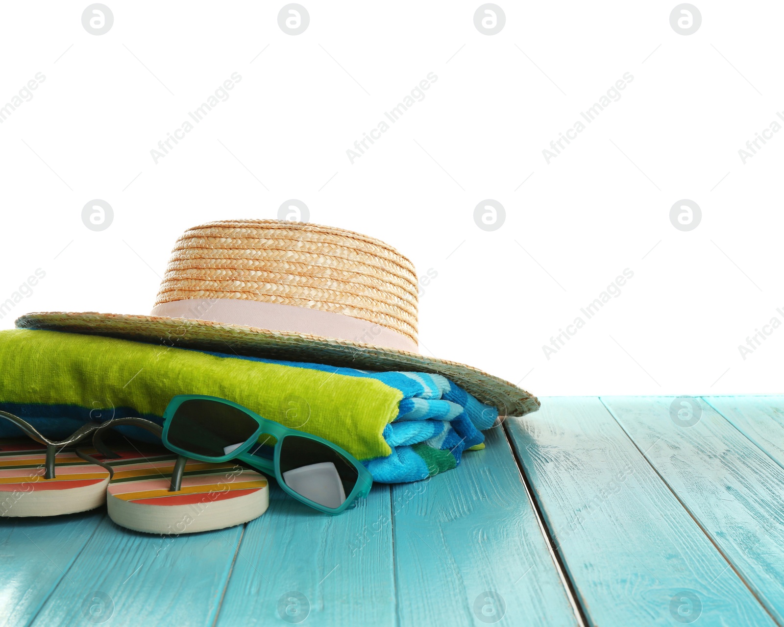 Photo of Hat, shoes, sunglasses and towel on light blue wooden table, space for text. Beach accessories