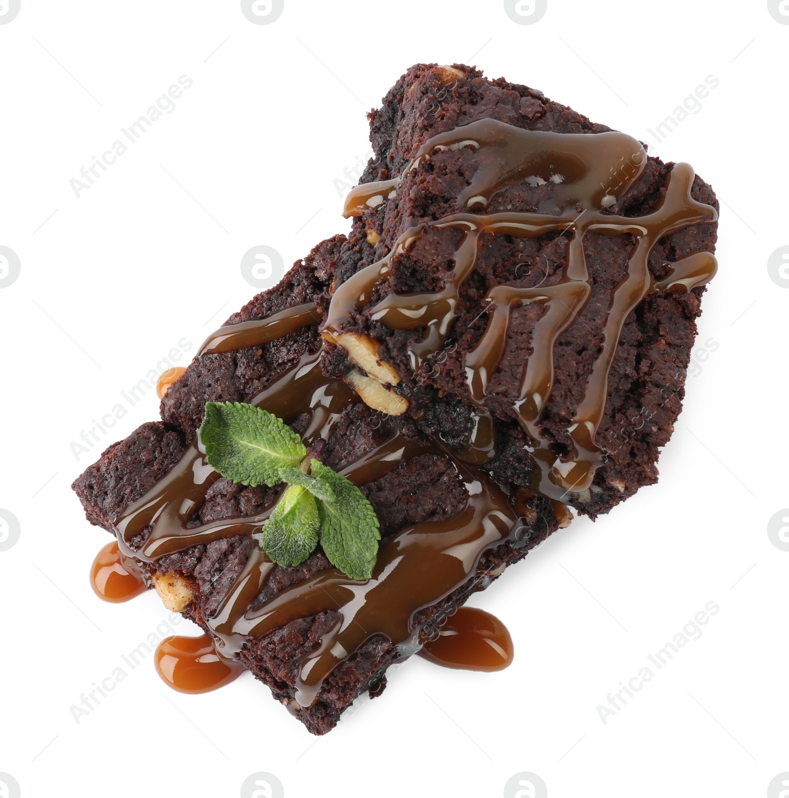 Photo of Delicious chocolate brownies with nuts, caramel sauce and fresh mint on white background, top view