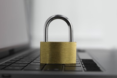 Cyber security. Metal padlock on laptop, closeup