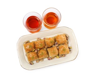 Delicious baklava with pistachios and hot tea on white background, top view