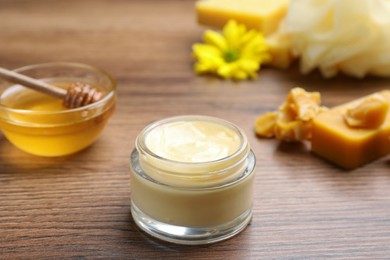 Photo of Cream with natural beeswax component on wooden table