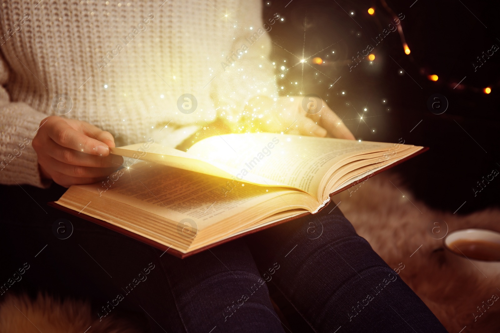Image of Woman reading shiny magic book, closeup view