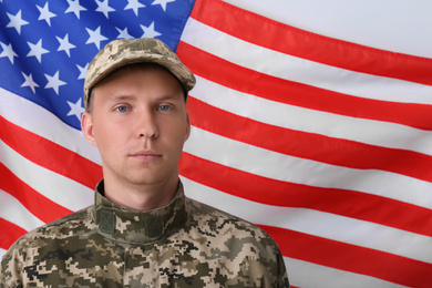 Soldier in uniform and United states of America flag on white background