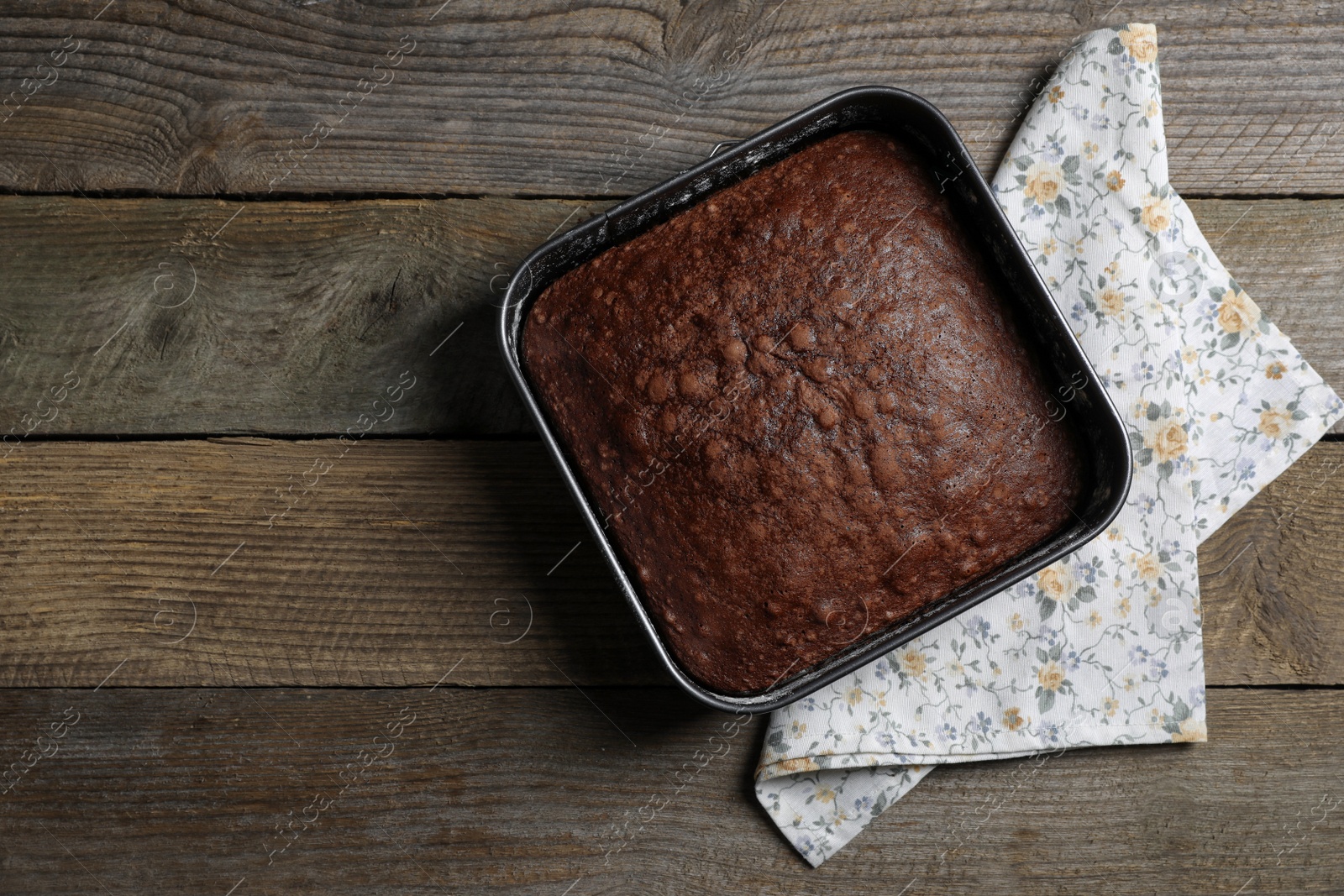 Photo of Homemade chocolate sponge cake on wooden table, top view. Space for text