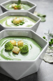 Photo of Fresh vegetable detox soup made of broccoli with croutons on table