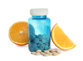 Bottle with vitamin pills and orange on white background