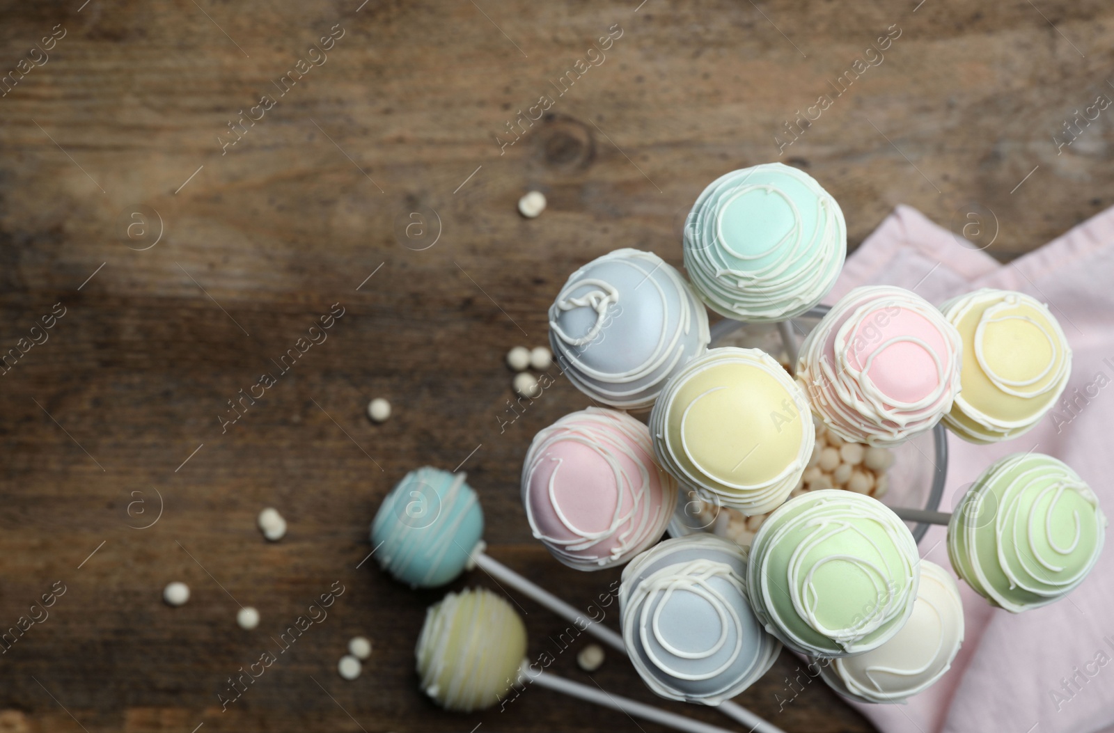 Photo of Sweet cake pops on wooden background, top view. Space for text