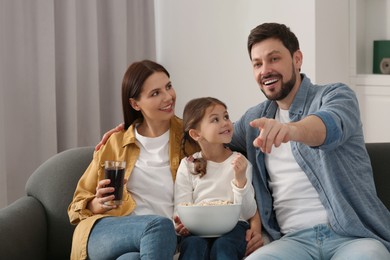 Photo of Happy family spending time together while watching TV at home