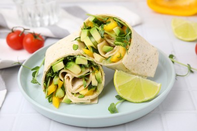 Photo of Delicious sandwich wraps with fresh vegetables and slice of lime on white tiled table