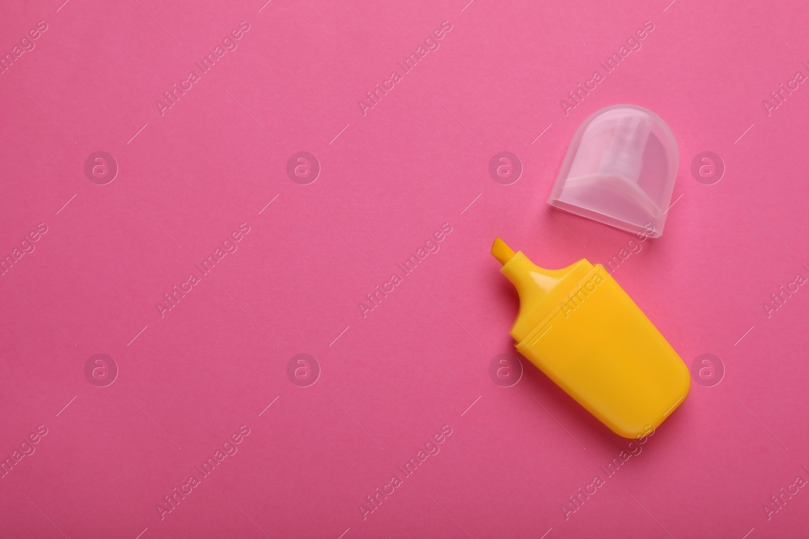 Photo of Yellow marker with cap on pink background, top view. Space for text