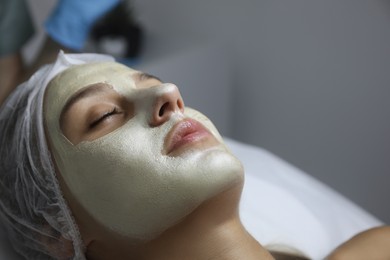 Beautiful woman with mask on her face in spa salon