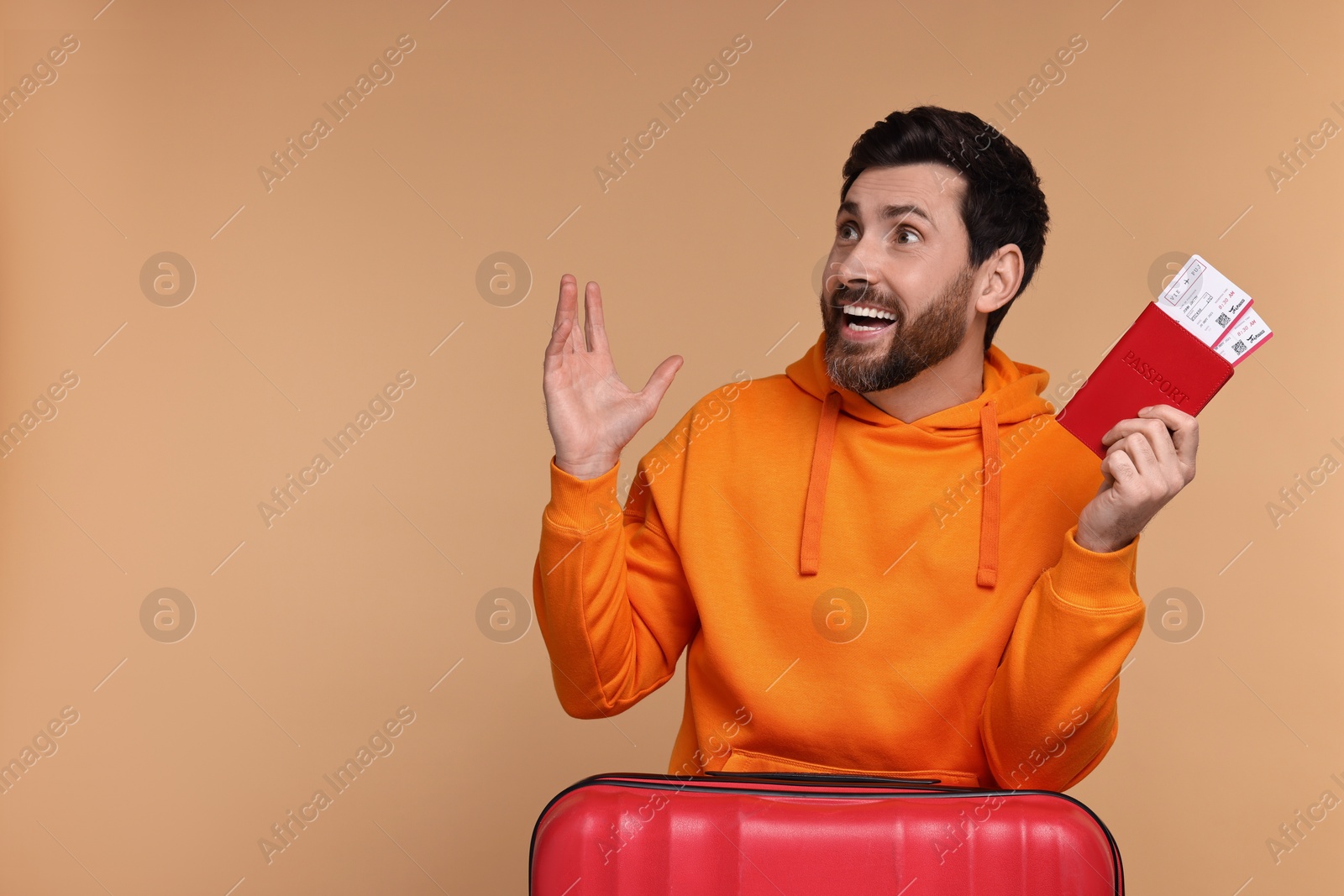 Photo of Happy man with passport, suitcase and tickets on beige background. Space for text