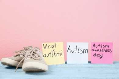 Photo of Notes with autism related phrases and child trainers on table