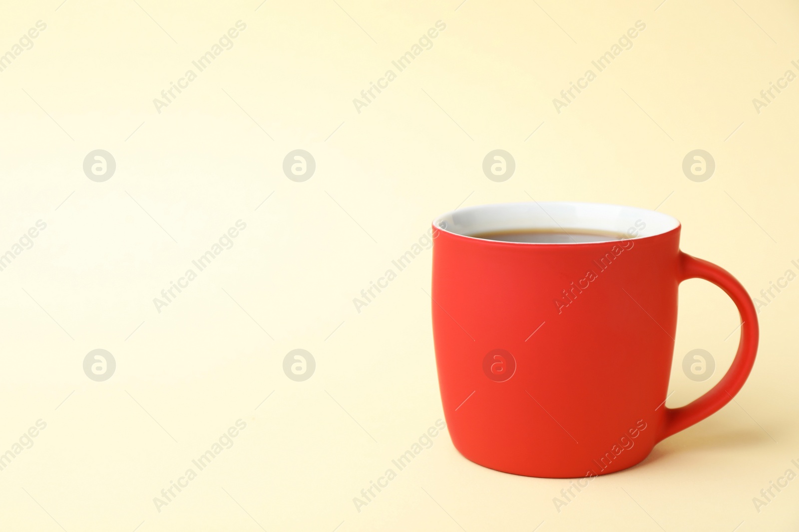 Photo of Red ceramic cup with hot aromatic coffee on color background