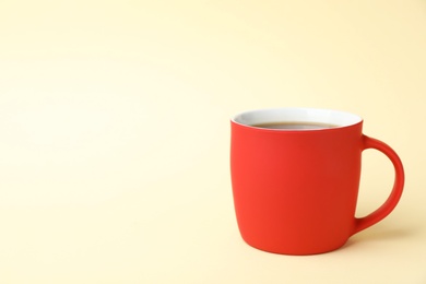 Photo of Red ceramic cup with hot aromatic coffee on color background