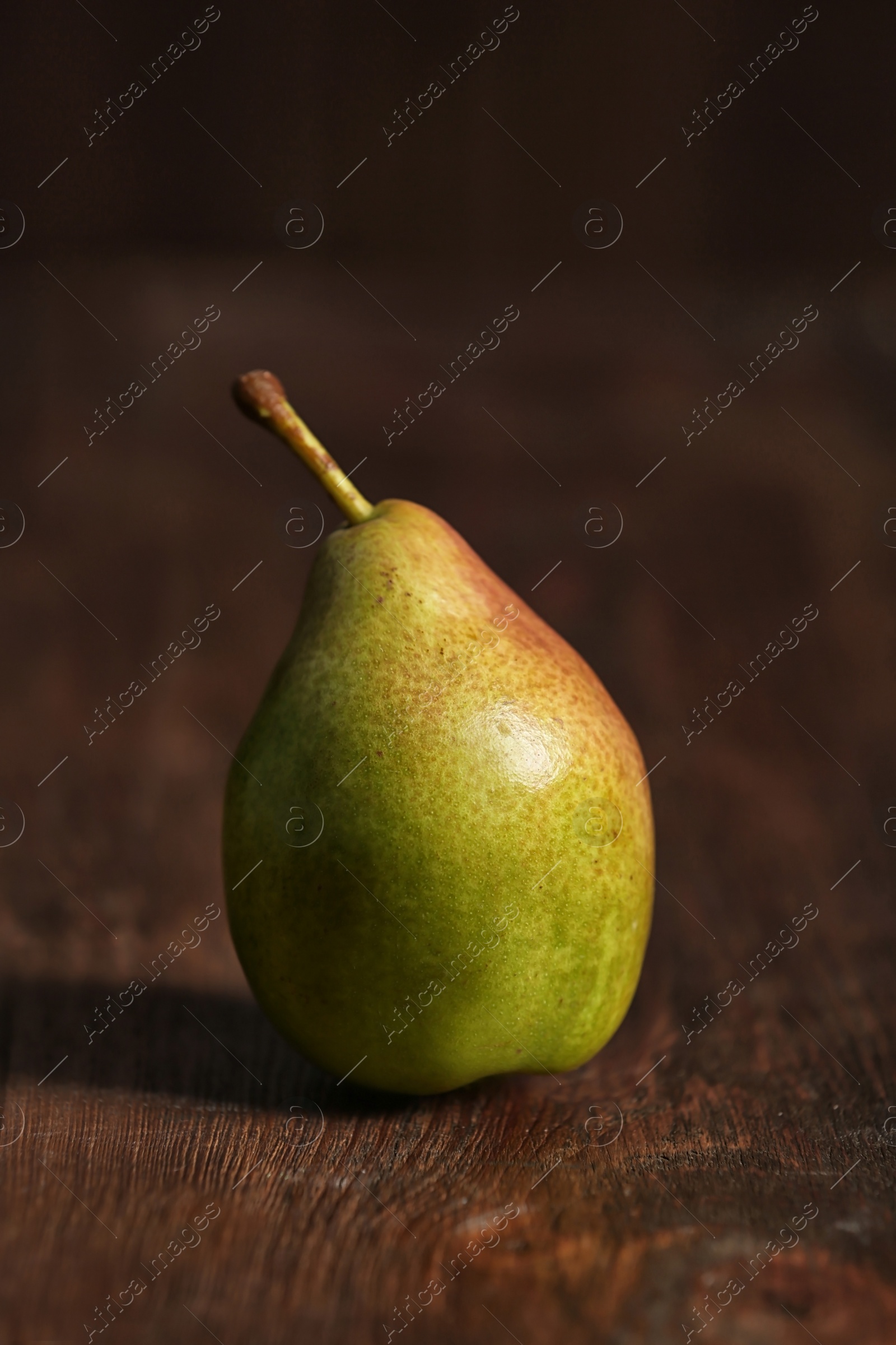 Photo of Tasty ripe green pear on wooden background