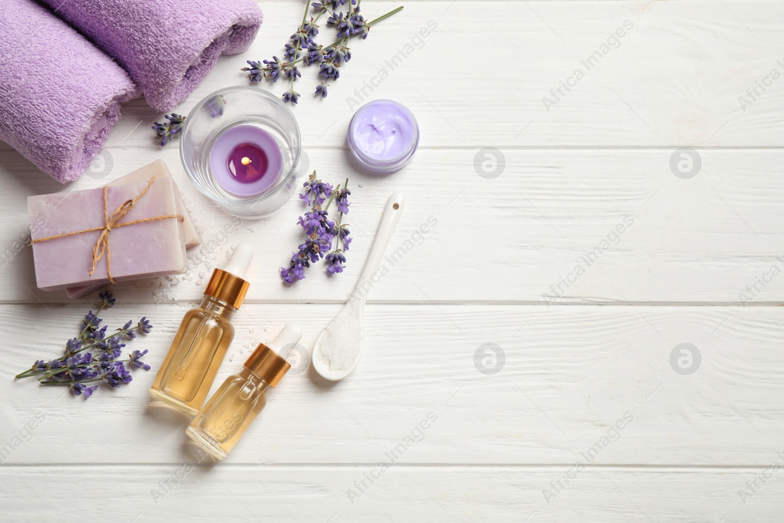 Photo of Flat lay composition with essential oil and lavender flowers on white wooden background. Space for text