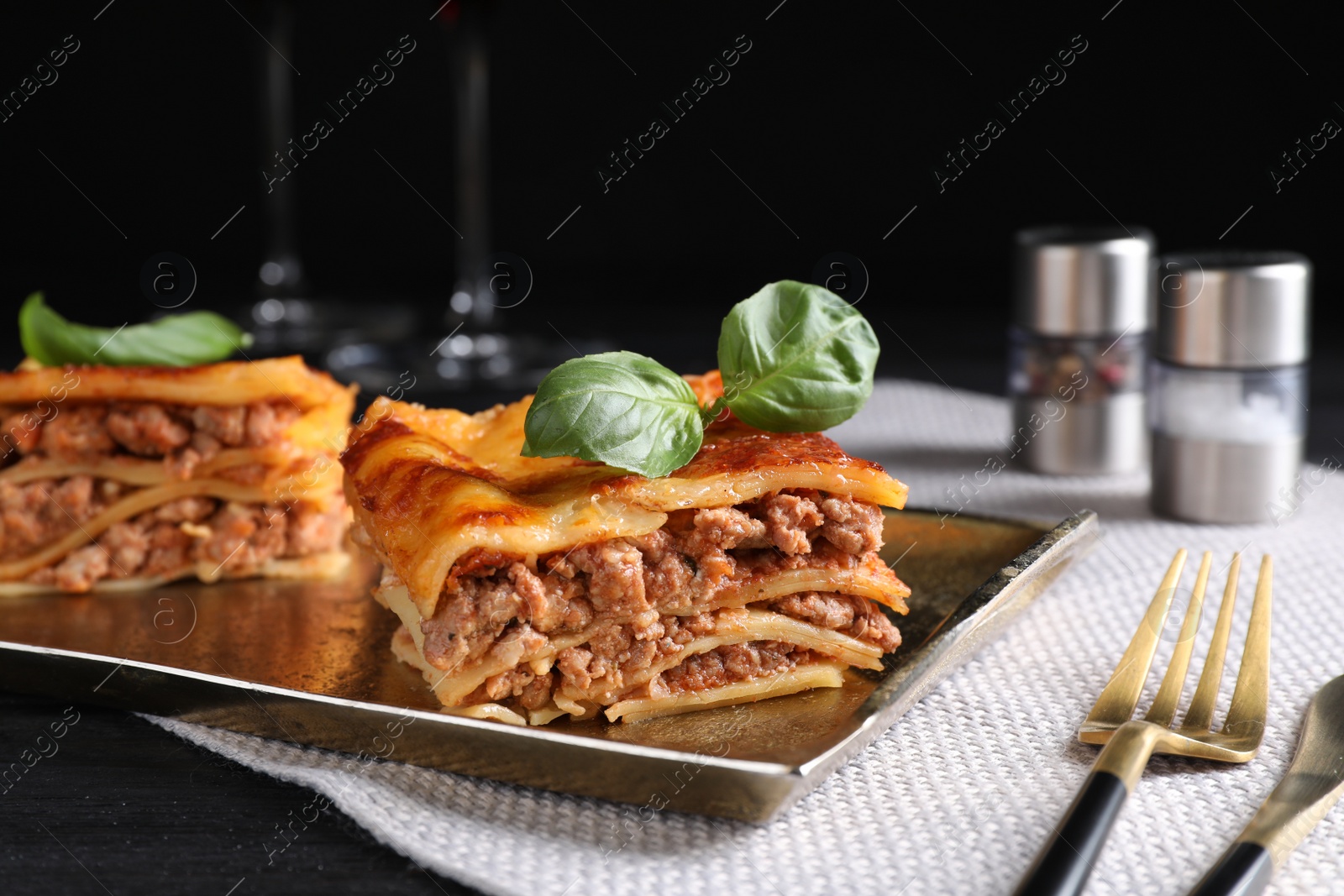 Photo of Delicious cooked lasagna served on black table