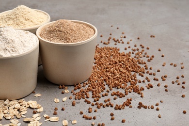 Composition with different types of flour on grey background