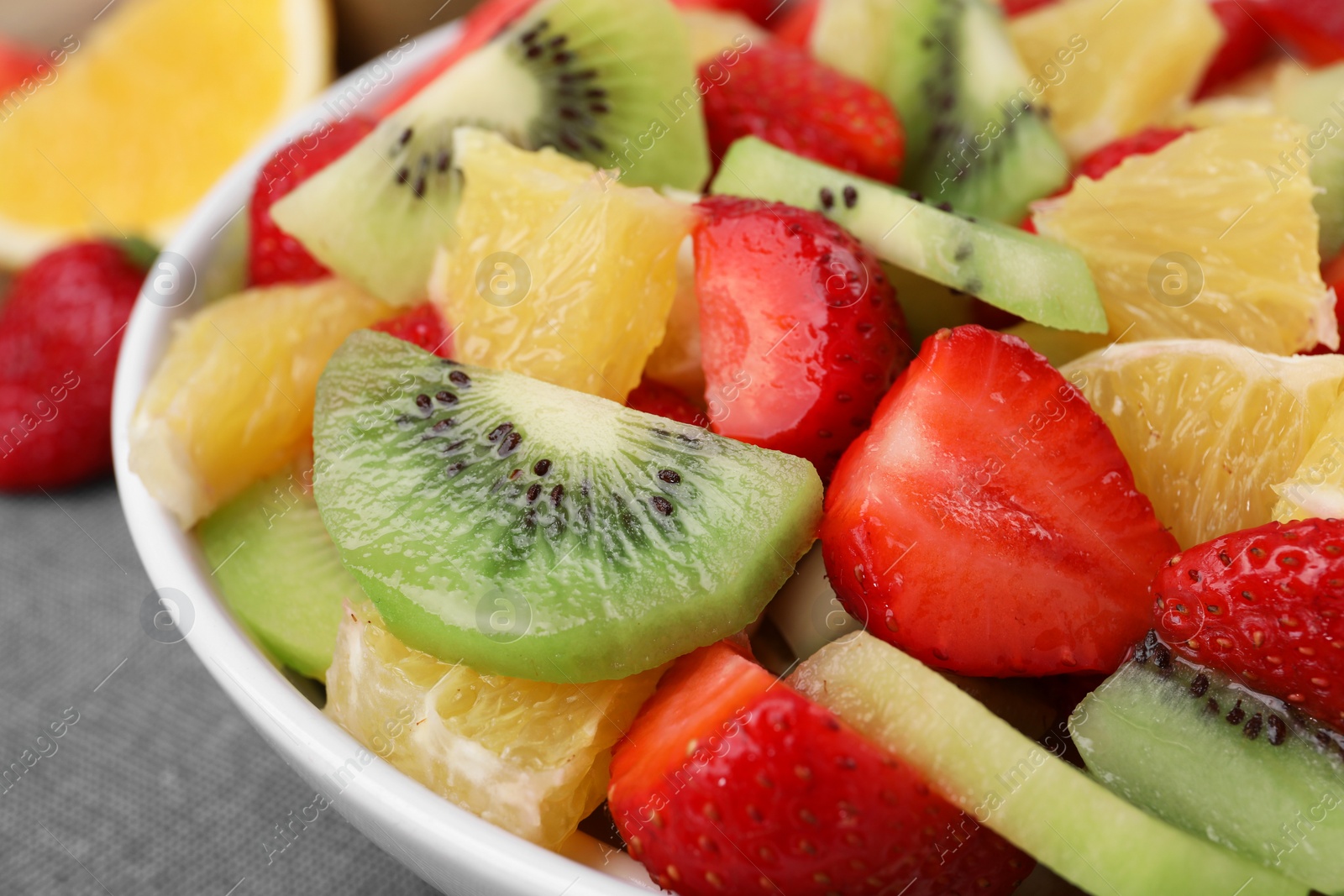 Photo of Delicious fresh fruit salad in bowl on table, closeup