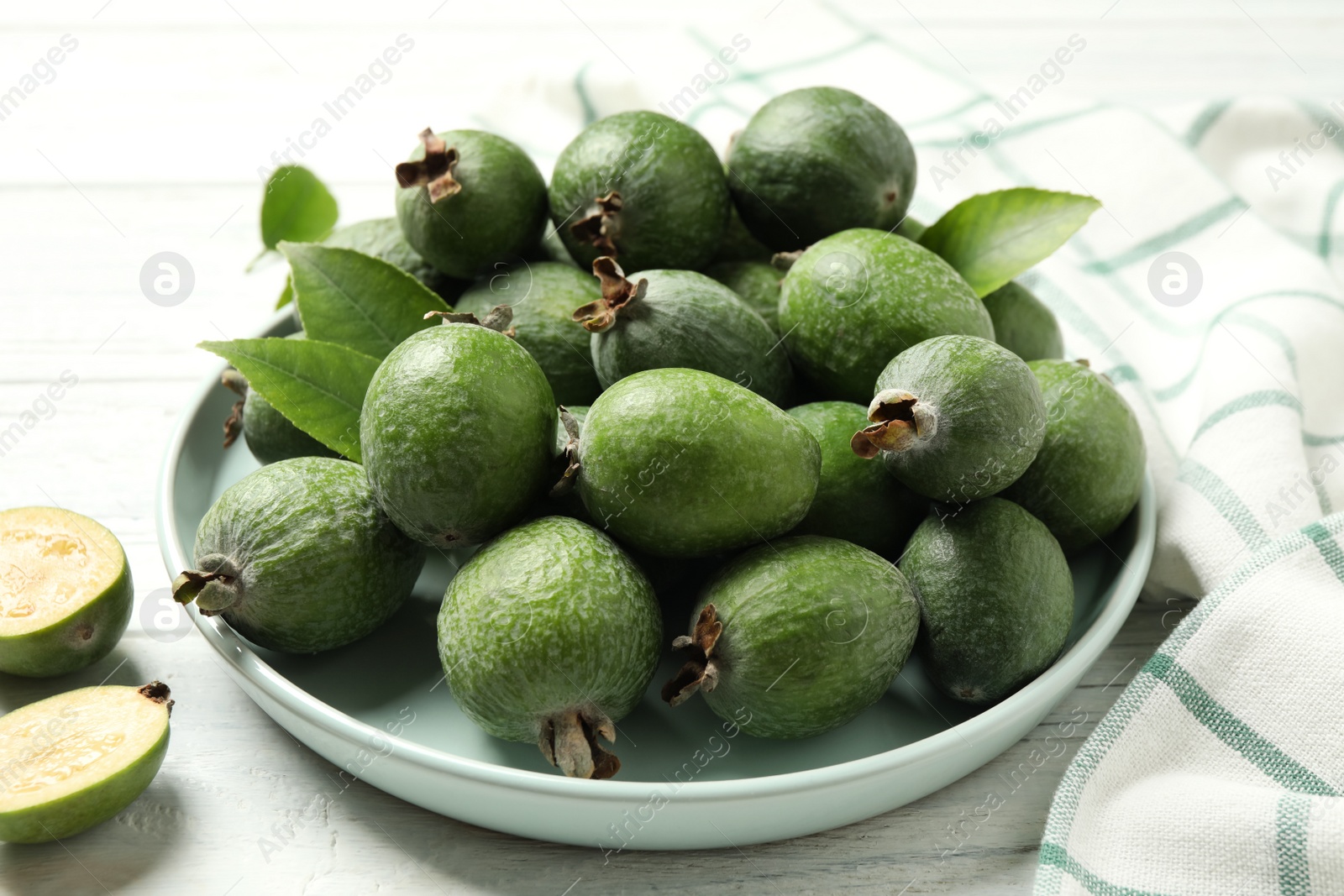 Photo of Fresh green feijoa fruits on white wooden table