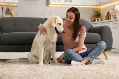 Happy woman with cute Labrador Retriever dog on floor at home. Adorable pet