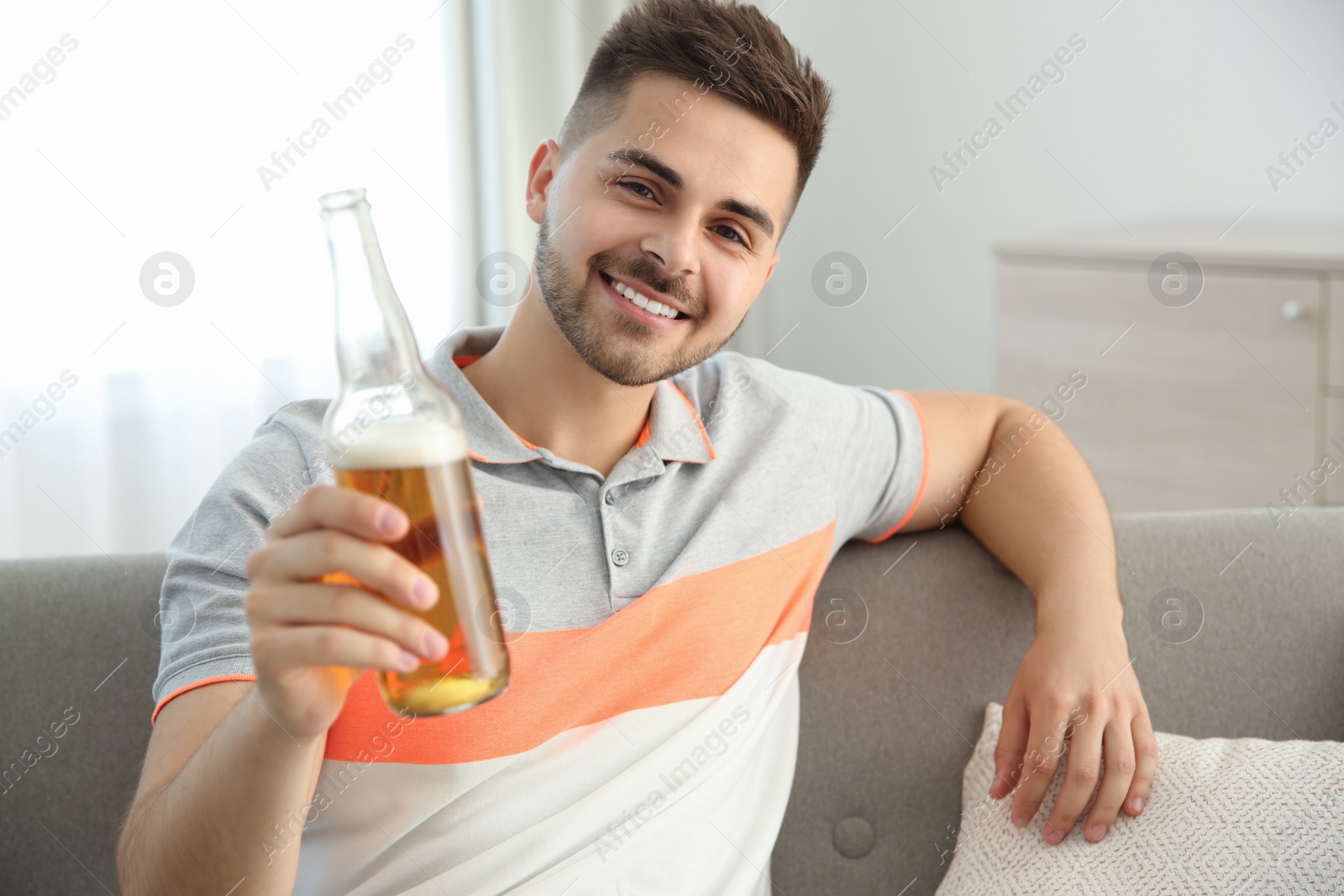 Photo of Man drinking beer while having online video conference at home, view from web camera. Social distancing during coronavirus pandemic