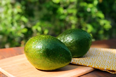 Fresh ripe avocados on wooden table outdoors