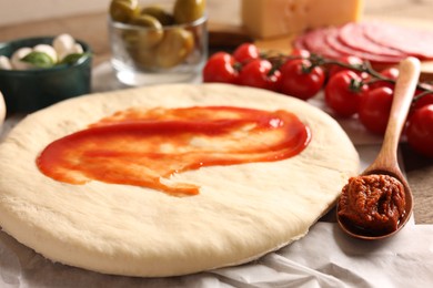 Pizza dough and products on table, closeup