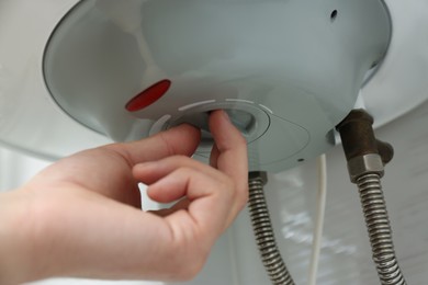 Woman adjusting maximum energy efficiency indicator indoors, closeup. Boiler installation