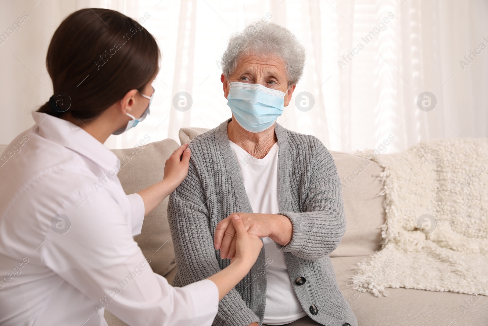 Photo of Doctor taking care of senior woman with protective mask at nursing home