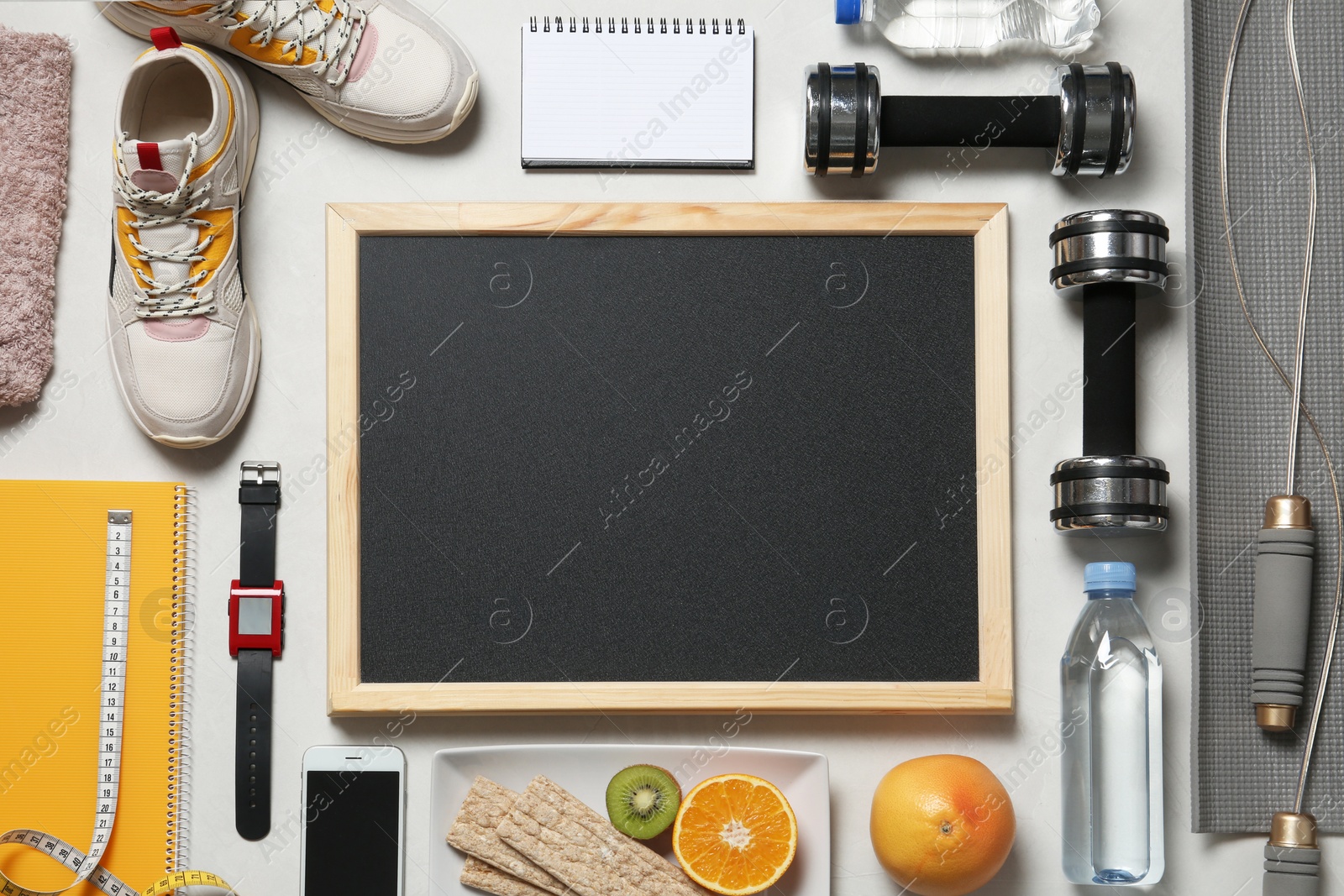 Photo of Flat lay composition with sport equipment and blackboard on gray background, space for text. Weight loss