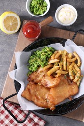 Tasty fish, chips, sauces and peas on grey table, flat lay