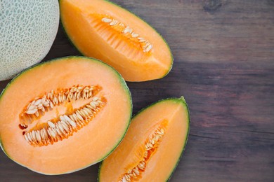 Tasty orange ripe melons on wooden table, flat lay. Space for text