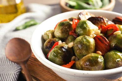 Bowl of warm salad with Brussels sprouts and carrots on table