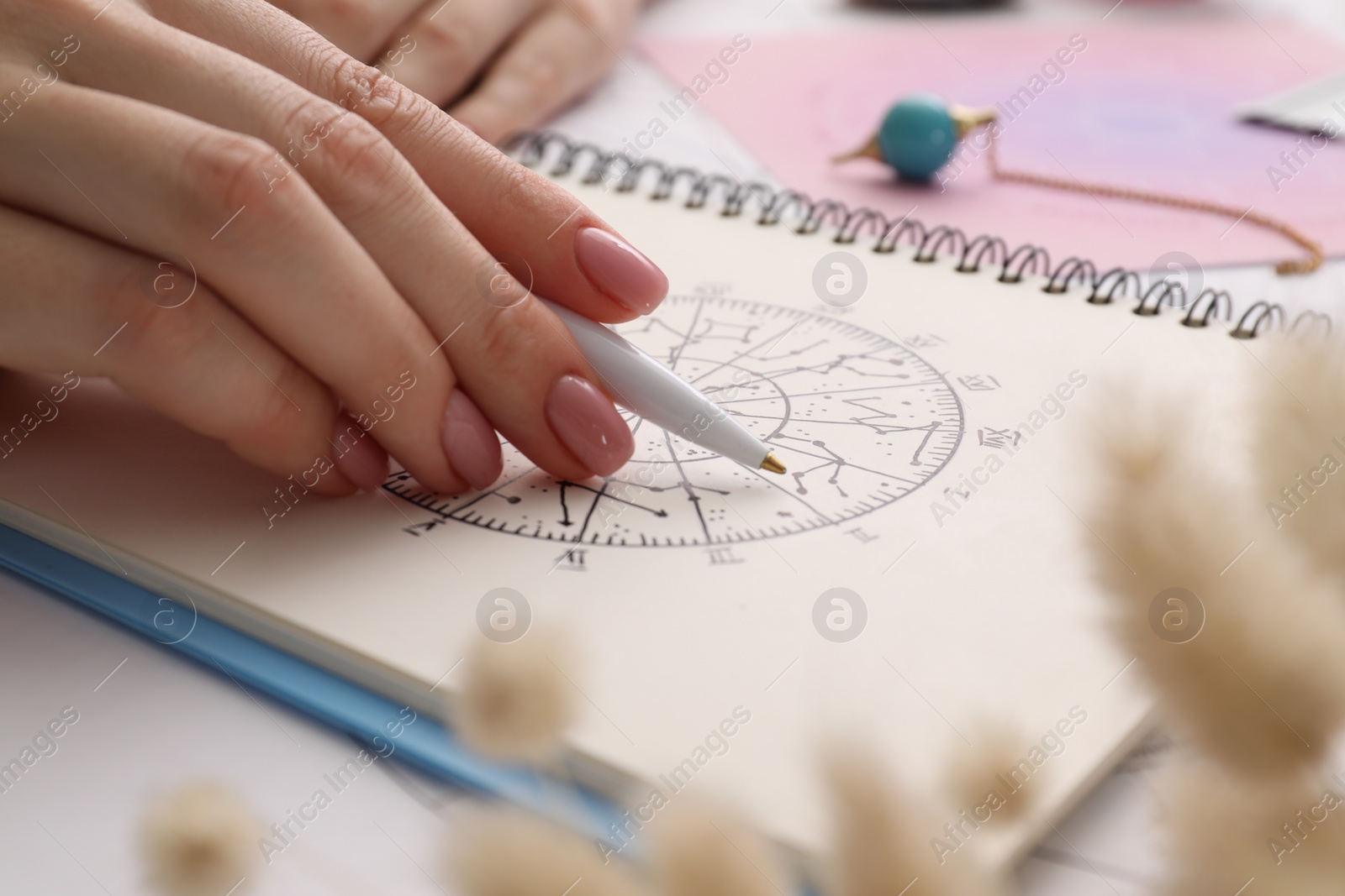 Photo of Astrologer using zodiac wheel for fate forecast at table, closeup. Fortune telling