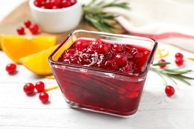 Photo of Cranberry sauce in bowl on white wooden table