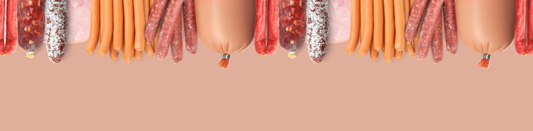 Many different tasty sausages on pale coral background, flat lay. Banner design