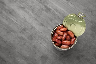 Photo of Tin can of canned kidney beans on grey table, top view. Space for text