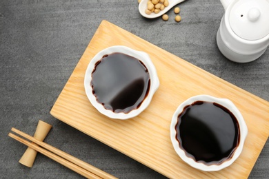 Dishes of soy sauce served on table, flat lay