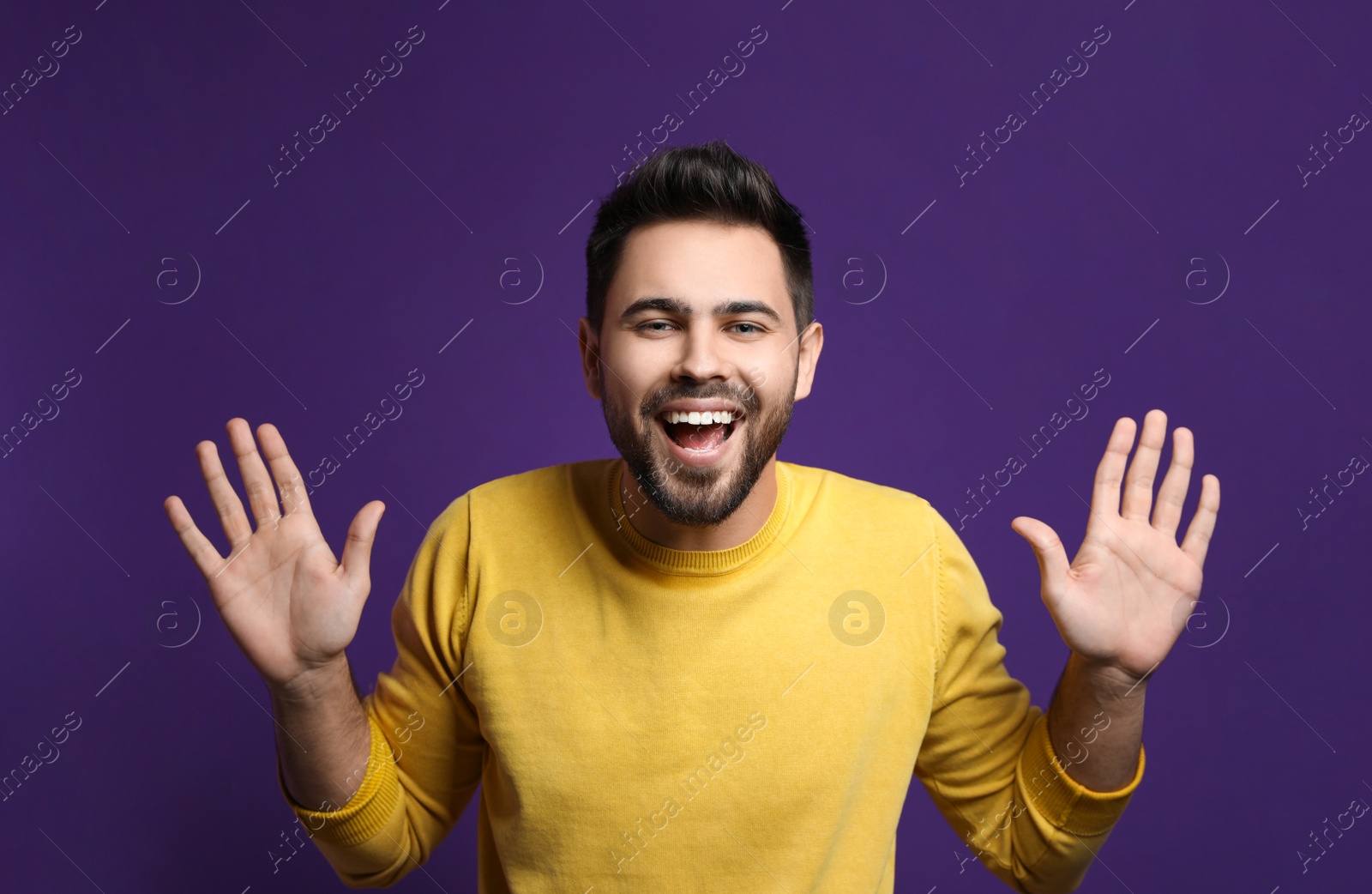 Photo of Young man laughing on purple background. Funny joke