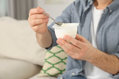 Photo of Man with delicious yogurt at home, closeup. Space for text