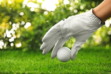 Photo of Player putting golf ball on green course, closeup