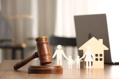 Photo of Law concept. Gavel, figures of parents with children and house on wooden table