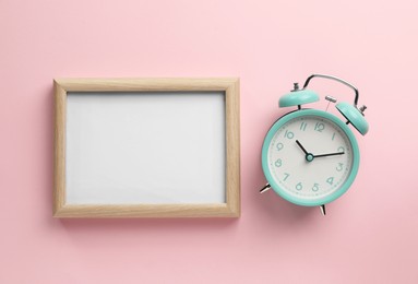 Photo of Blank white board with alarm clock on light pink background, flat lay. Space for text