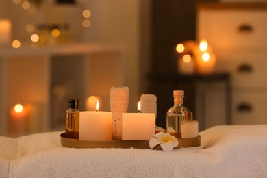 Photo of Cosmetics and burning candles on massage table in spa salon